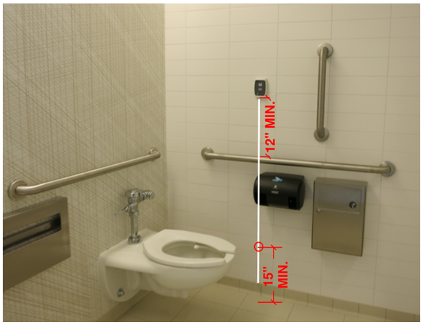 Bathroom with a nurse call device installed near the toilet 12 inches above a grab bar.