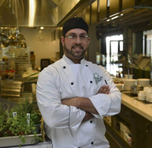 Chris Galarza in a commercial kitchen in chef's uniform