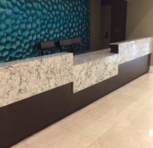 Hotel reception desk with a lowered accessible counter section for guest check-in.