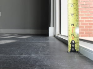 A measuring tape shows a height of 1.5 inches from the top of the interior finished floor to the top of the sliding door track.