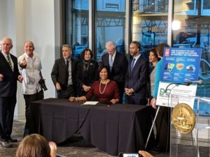 District of Columbia Mayor Muriel Bowser smiles at the crowd after signing the Clean Energy Omnibus Amendment Act in Washington, DC.