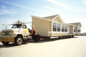 A manufactured home being transported by truck.