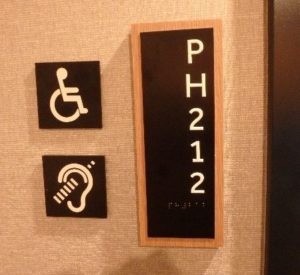 Hotel penthouse guest room door with accessibility signage mounted beside the entrance.