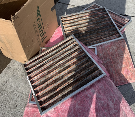 Several dirty and deteriorated HVAC filters removed during maintenance, showing significant buildup from long-term neglect.