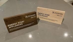 Two wooden tabletop signs promoting ENERGY STAR® appliances, displayed as marketing materials for green building programs. These silent seller signs highlight energy-efficient appliance options that align with National Green Building Standard (NGBS) requirements and sustainability goals.