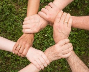 Image of different generations of people linking arms