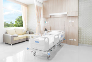 image of clean hospital bed and visitor's couch in a hospital room