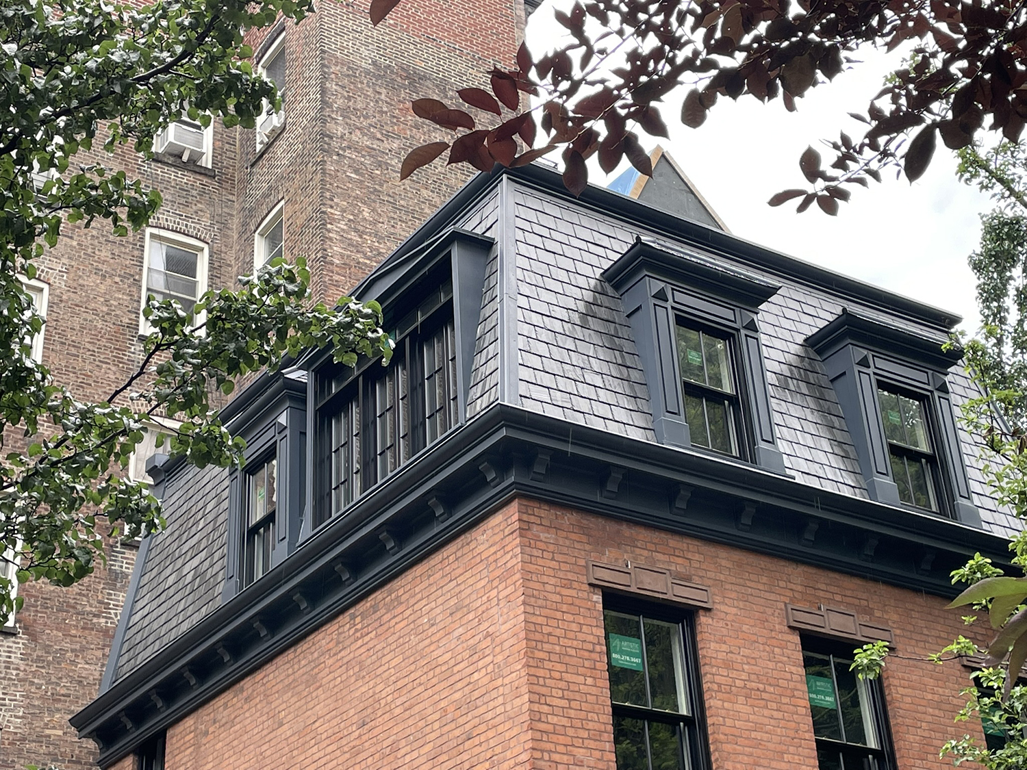 Finished mansard roof with slate cladding and dormer windows following restoration of the Twin Sisters townhouses on Commerce Street.